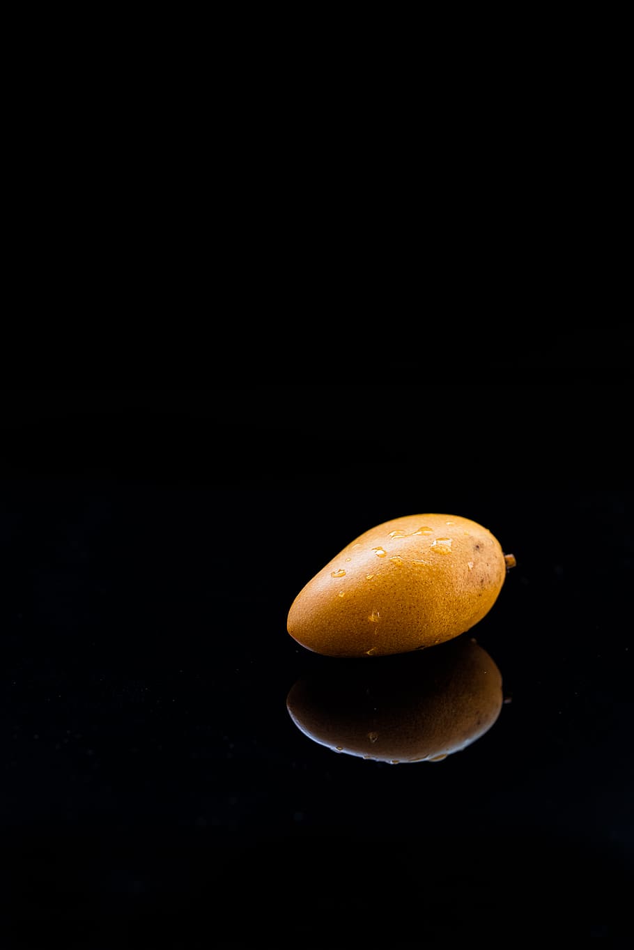 ripe mango reflected on black surface, studio shot, black background HD wallpaper