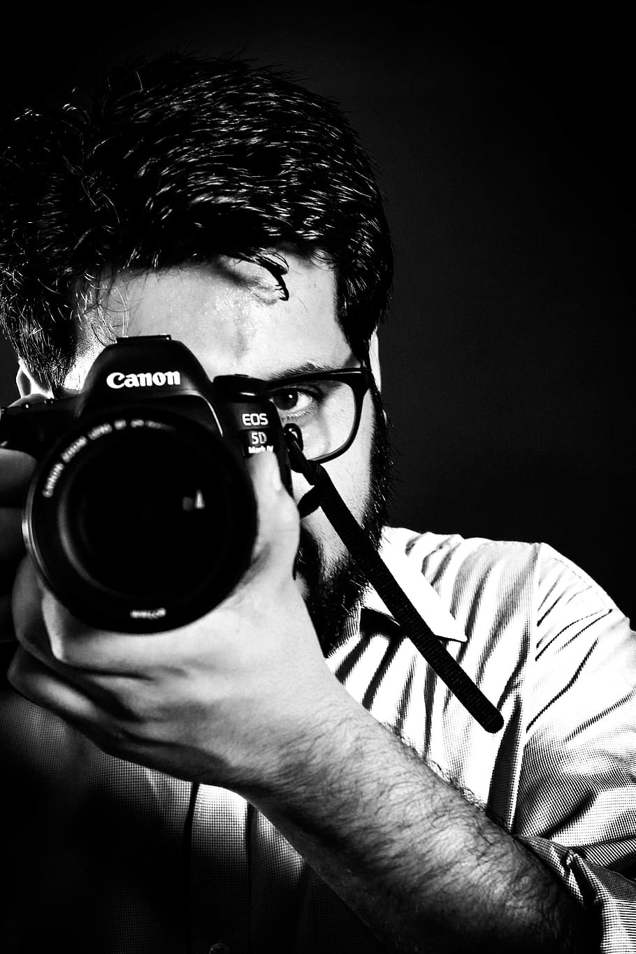 Man Taking Picture Front of Camea, black and white, black background