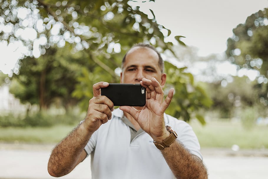 Man Holding Phone, blur, cellphone, depth of field, device, electronics HD wallpaper