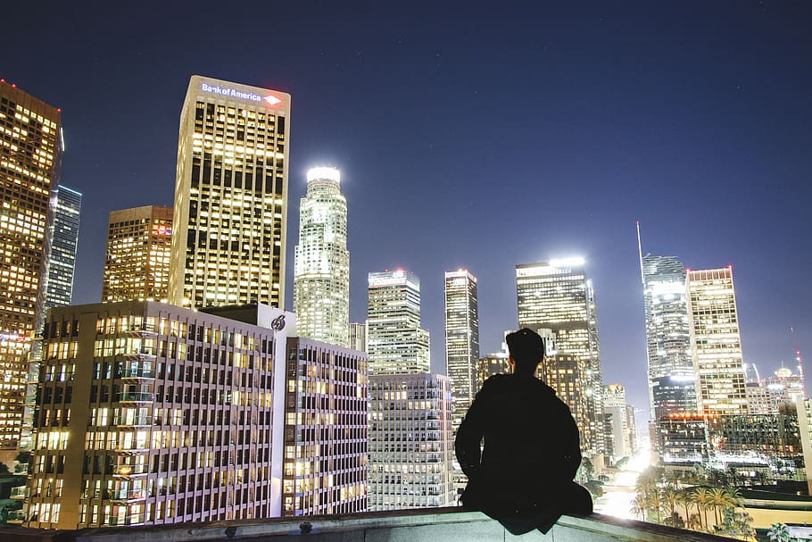man sitting on rooftop during nighttime, city, urban, building