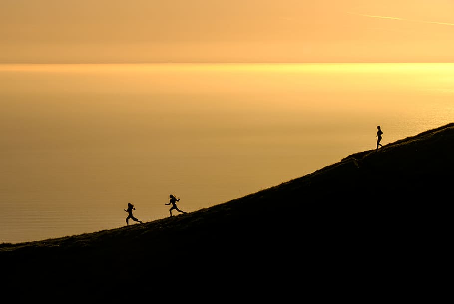 three persons running downhill during golden hour, silhouette HD wallpaper