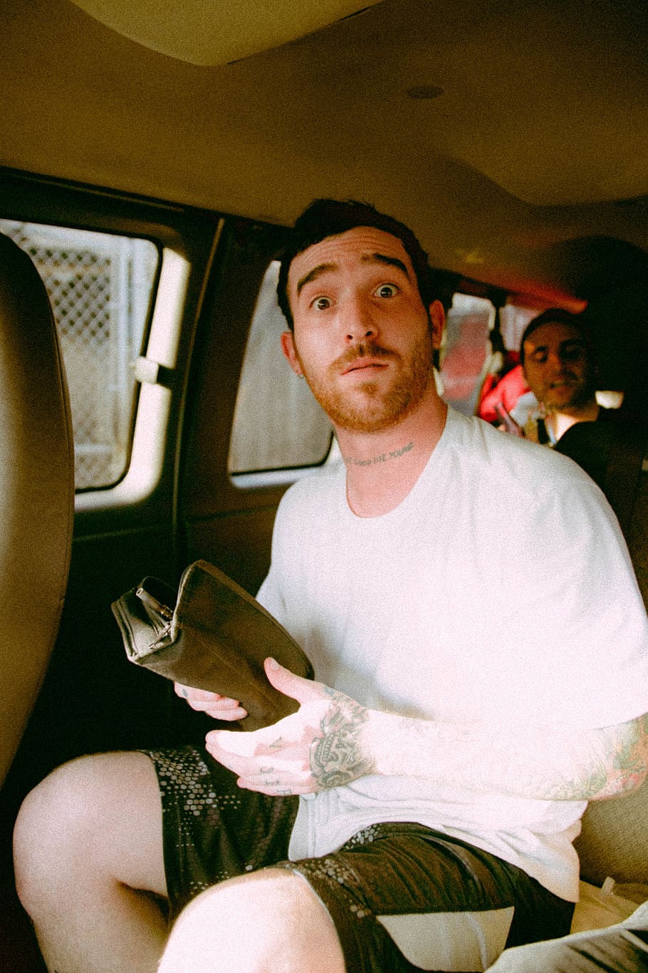 man sitting inside vehicle while holding book, cushion, person HD wallpaper