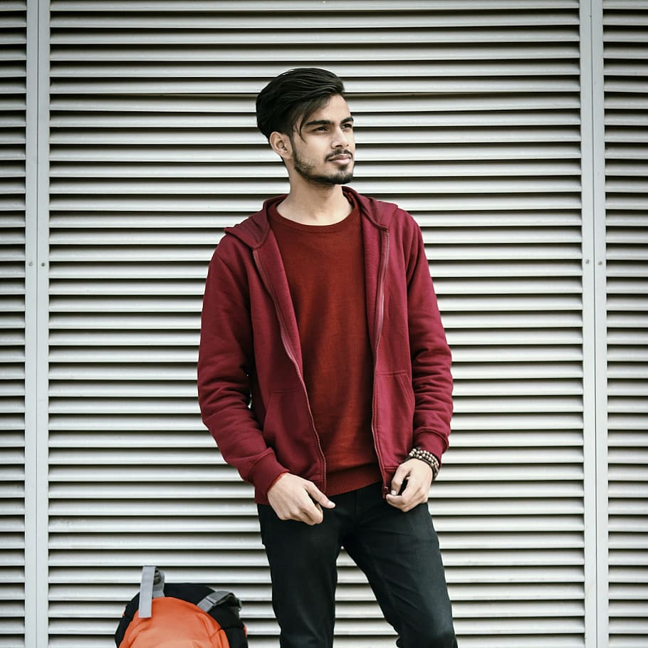 man in red jacket standing beside backpack, front view, three quarter length HD wallpaper
