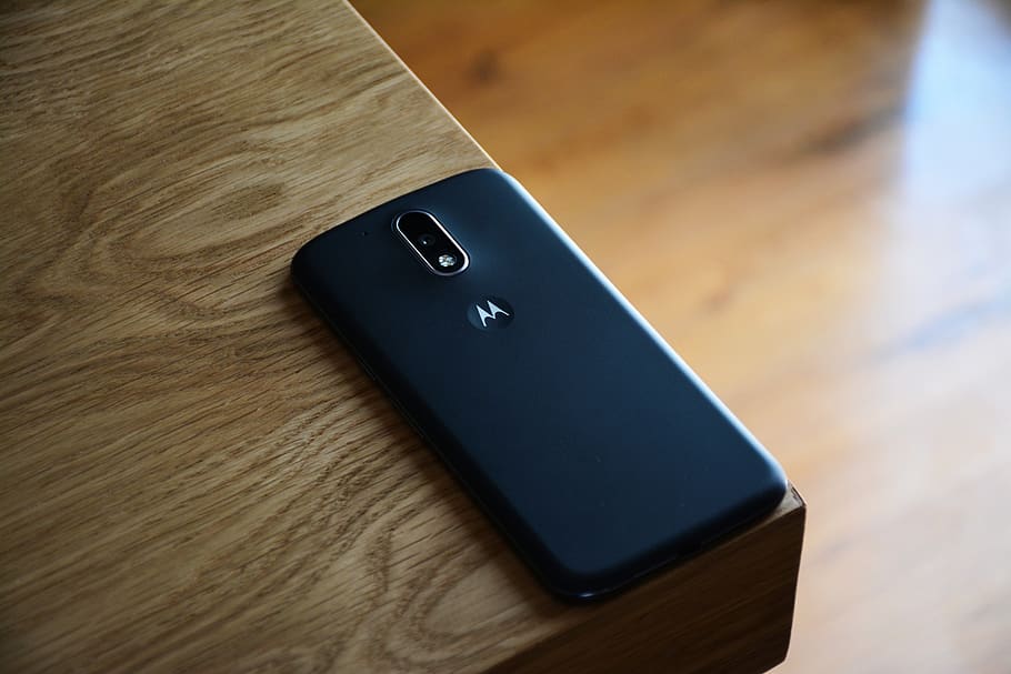 Black Motorola Smartphone on Top of Brown Wooden Table, desk HD wallpaper