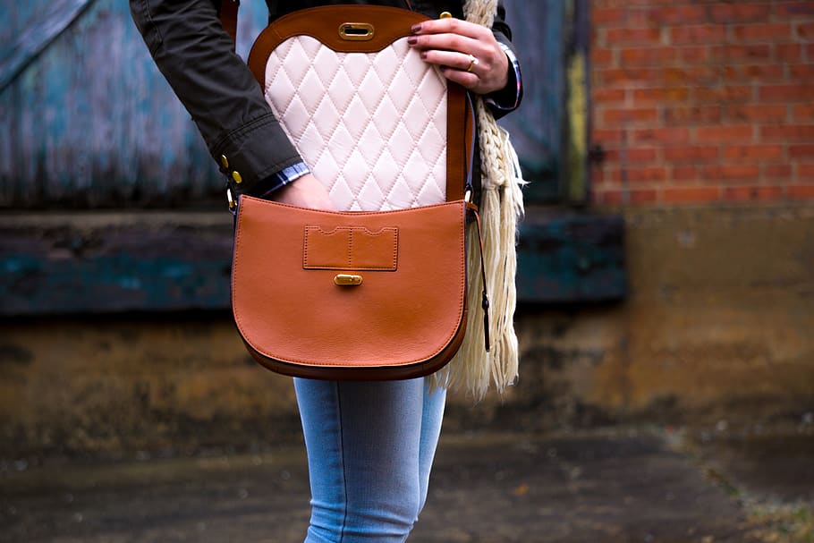 woman wearing red leather crossbody bag, one person, midsection