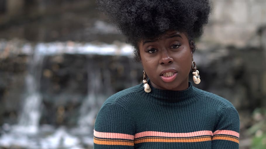 woman wearing gray sweater and earrings, hair, afro hairstyle