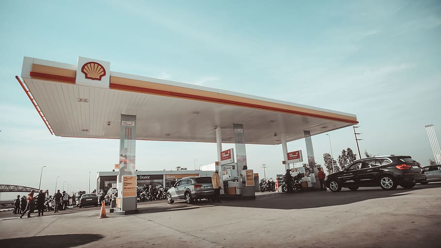 vehicles and people on Shell gasoline station during daytime