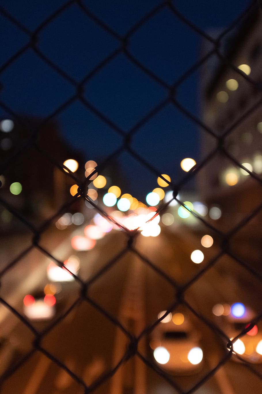 selective focus photo of chain-link fence, flare, light, handrail