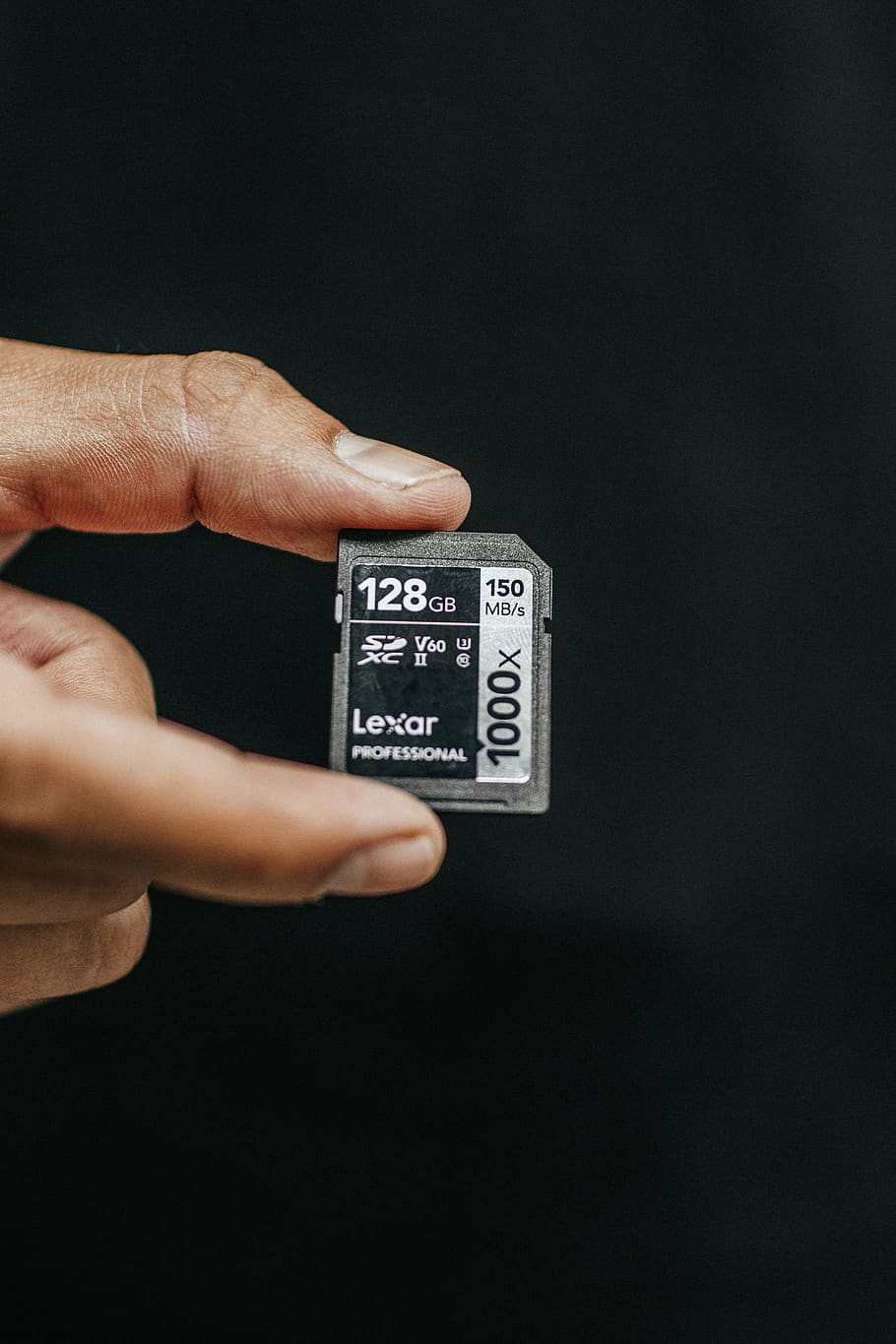 Person Holding Lexar 128gb Sd Card, black background, close-up HD wallpaper