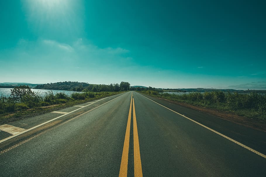 Panoramic Photography of Road Between Grasses and Body of Waters HD wallpaper