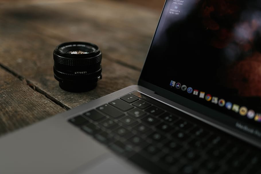 Shallow Focus Photography Of Black Zoom Lens Beside Macbook Pro HD wallpaper