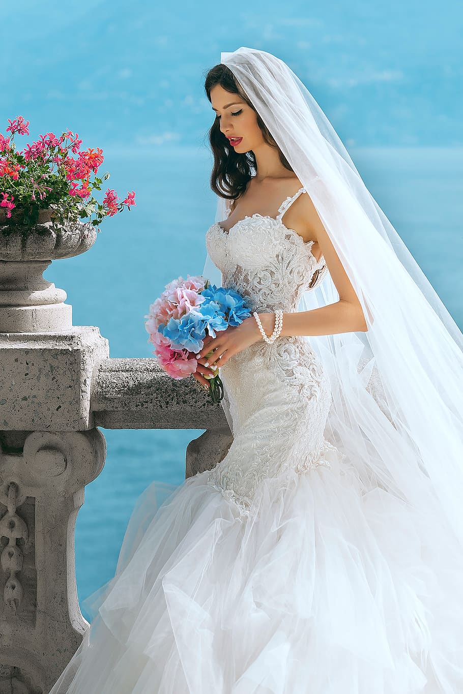 woman in wedding dress while holding flower during daytime, apparel