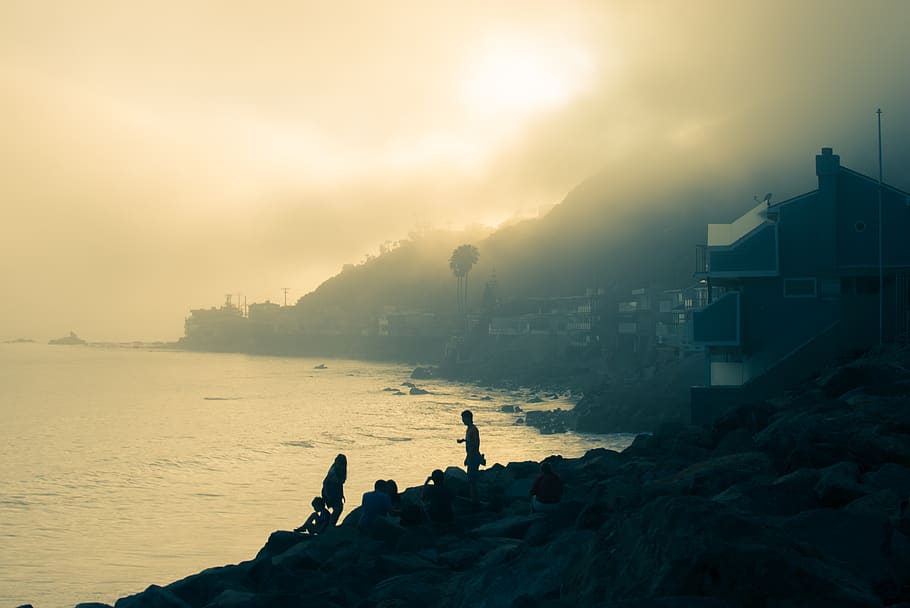 fog, ocean, rocks, beach, mountain, house, people, sun, water HD wallpaper
