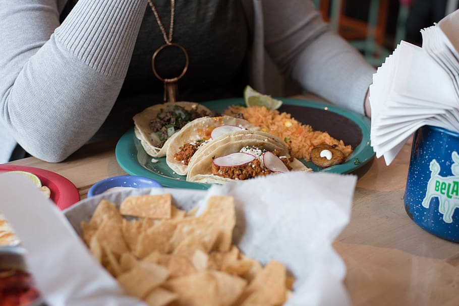 Person Sitting in Front of Tacos on Plate, chips, close-up, cuisine