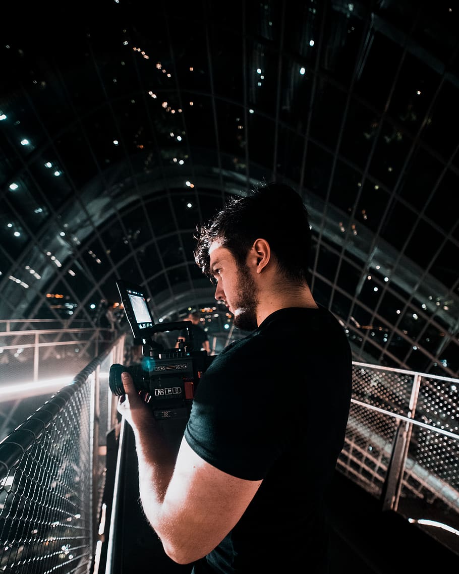 man wearing black shirt holding video camera, human, person, lighting, HD wallpaper
