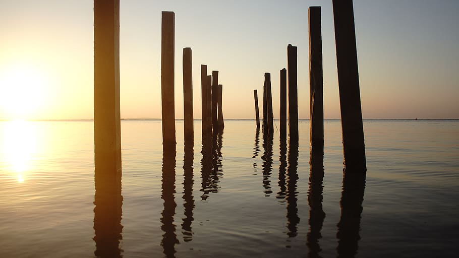 reflection, sunset, beach, sea, pillars, gold, brown, wood HD wallpaper