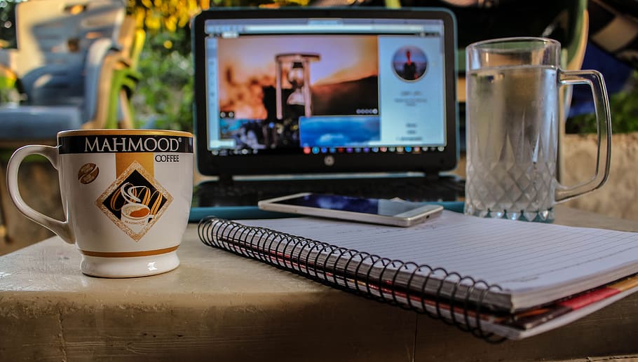 White Smartphone on Spiral Notebook Between Ceramic Mug and Glass Beer Mug Near Black Computer Monitor Showing Hour Glass, HD wallpaper