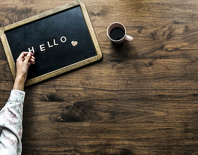 Person's Hand on Black Board With Hello Text Beside Brown Mug HD wallpaper
