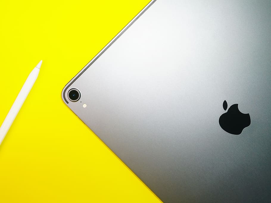 silver iPad on yellow surface, no people, close-up, two objects HD wallpaper