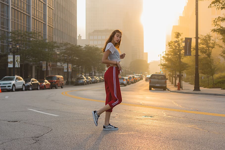 HD wallpaper: woman wearing white T-shirt and red track pants standing in  the middle of black concrete road