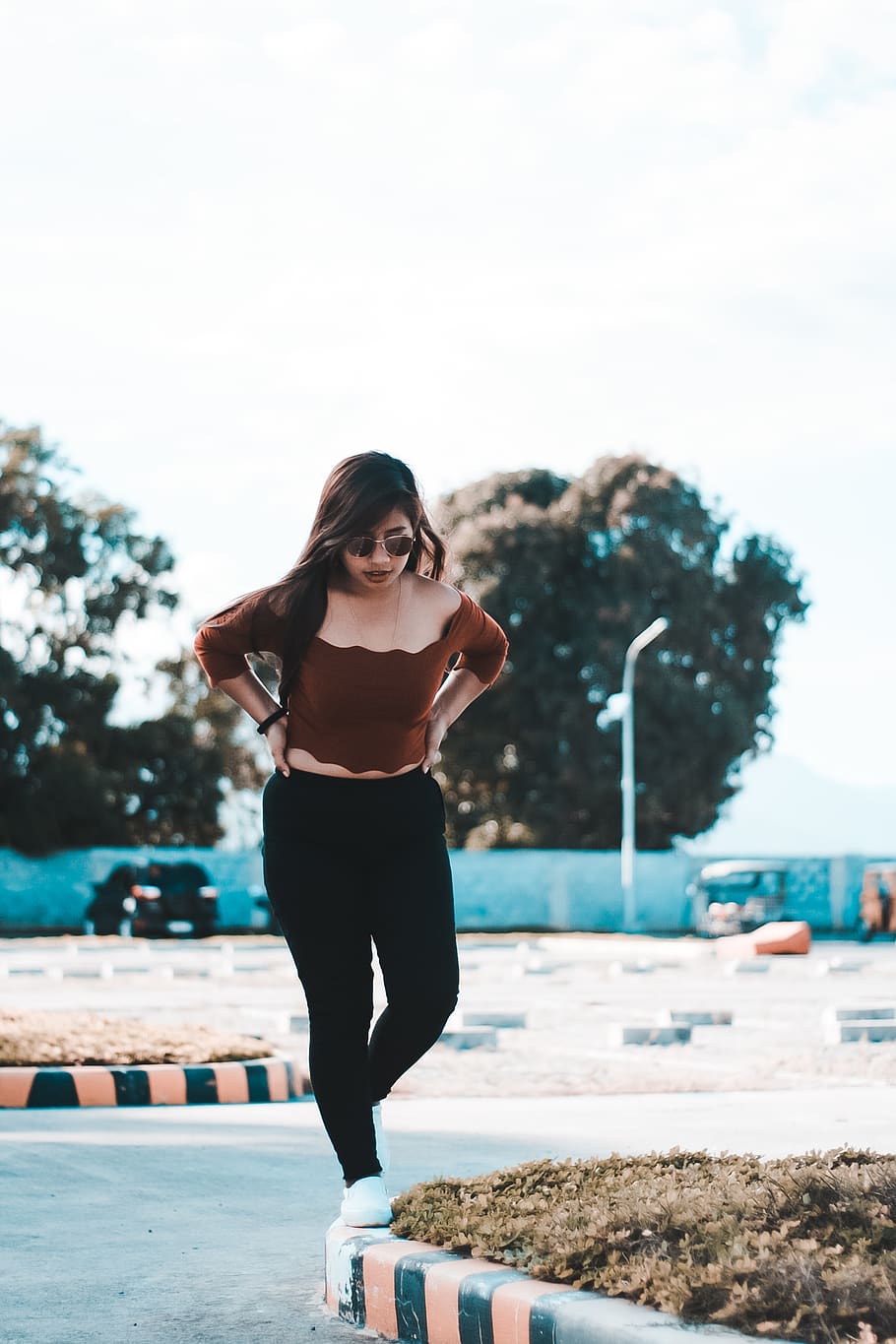 selective focus photography of woman wearing brown off-shoulder blouse and black pants