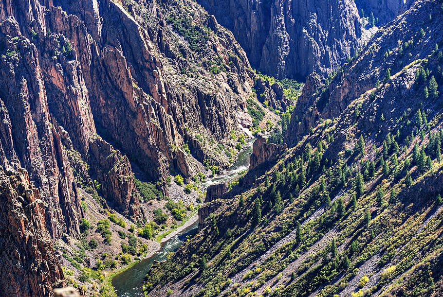This is a view of the Gunnison River as it flows at the bottom of the canyon. The Black Canyon of the Gunnison has extremely steep cliff walls and some of the oldest rock in North America. These canyon views, including this one, are easily accessible from the lookouts along the South Rim Road. This National Park is just north off US route 50 between the Curecanti National Recreation Area and Montrose, Colorado.