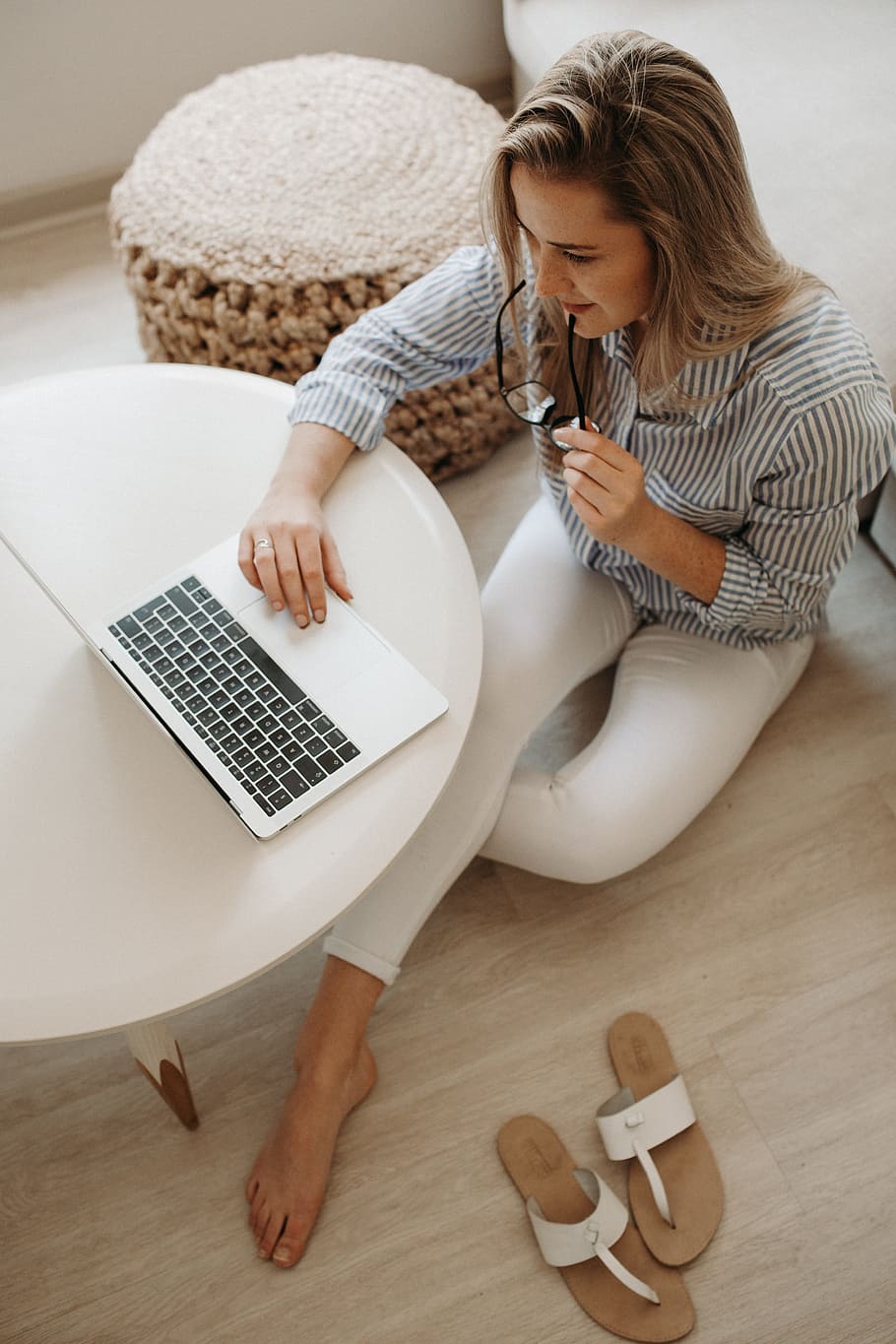 woman in white and black striped dress shirt sitting on floor in front of table while using laptop computer, HD wallpaper