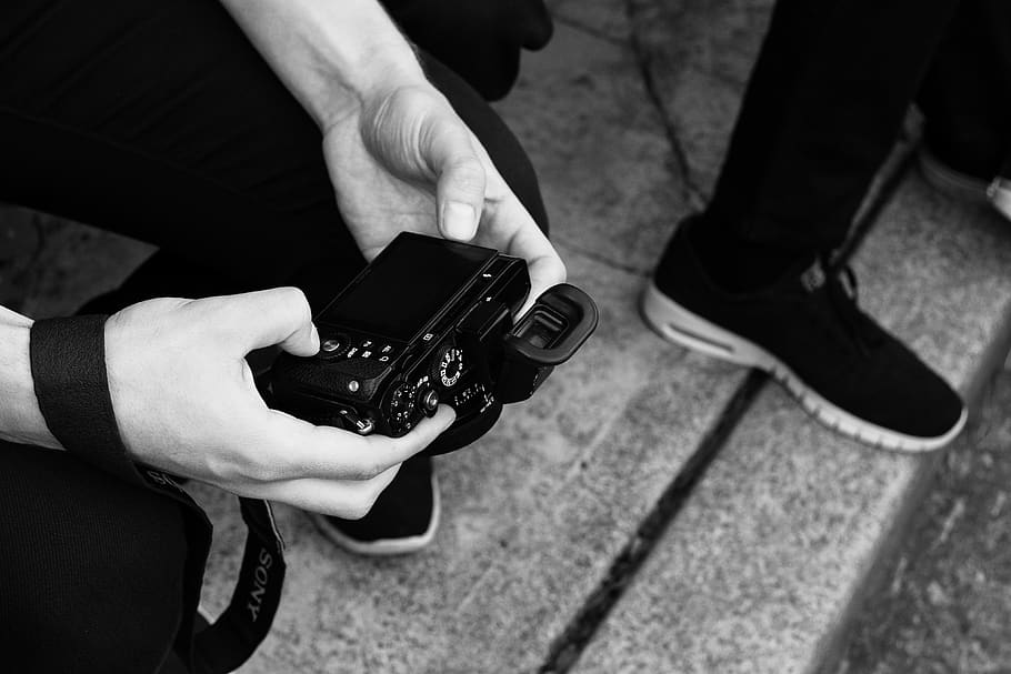 person holding digital camera while sitting, shoe, apparel, clothing HD wallpaper