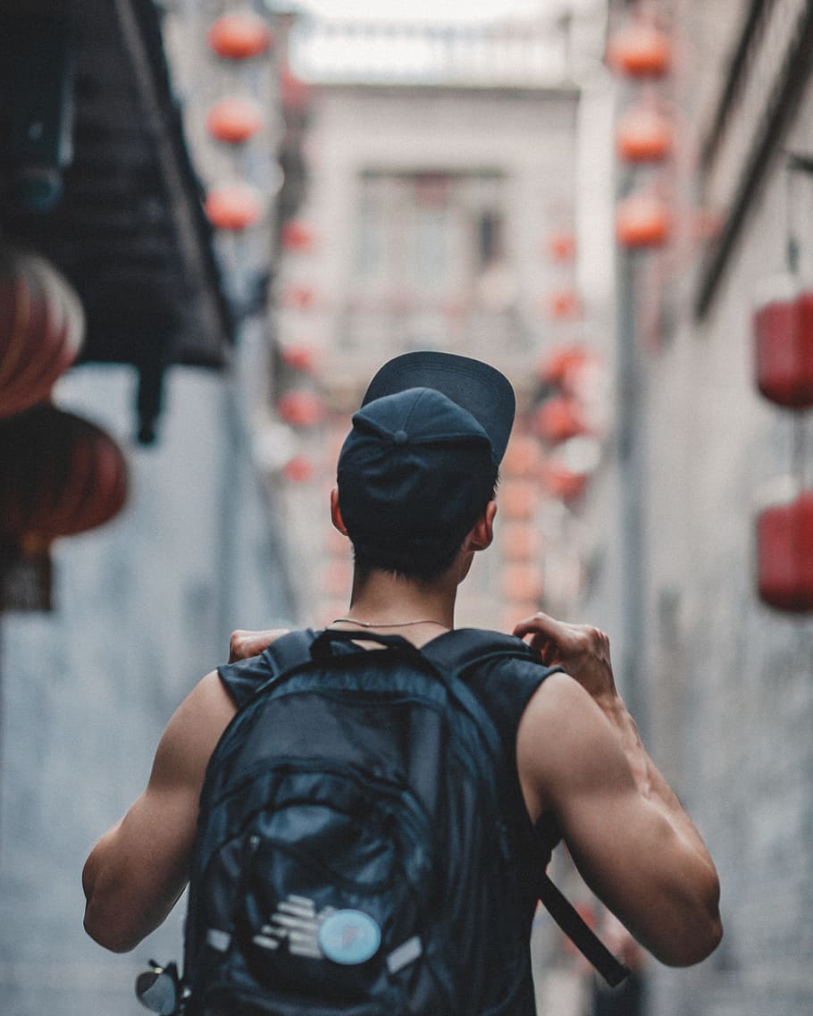 man holding black backpack, travel, person, walking, china, wander
