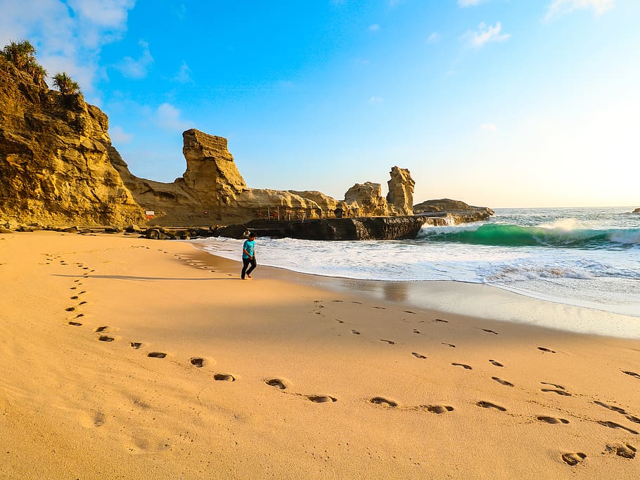 Person Walks on Brown Seashore Near Rock Formations, beach, clouds HD wallpaper