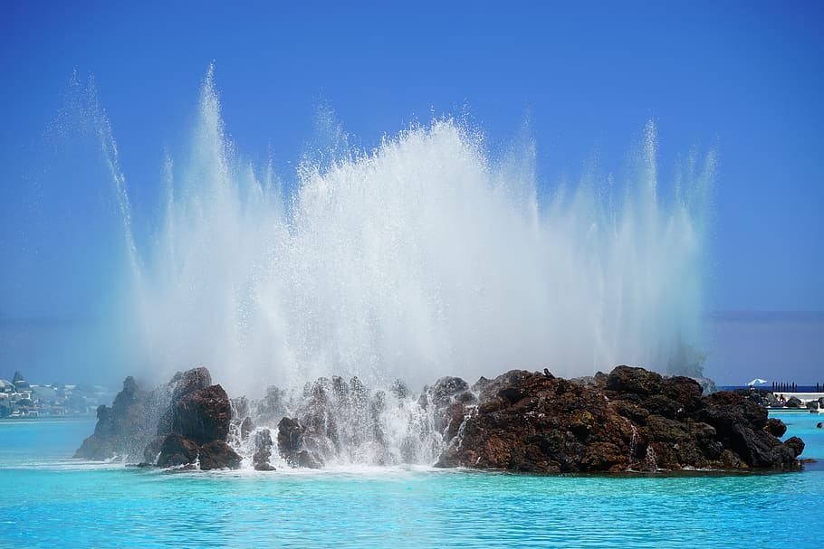 Brown Rock Island on Sea Water Under Blue Sky during Daytime HD wallpaper