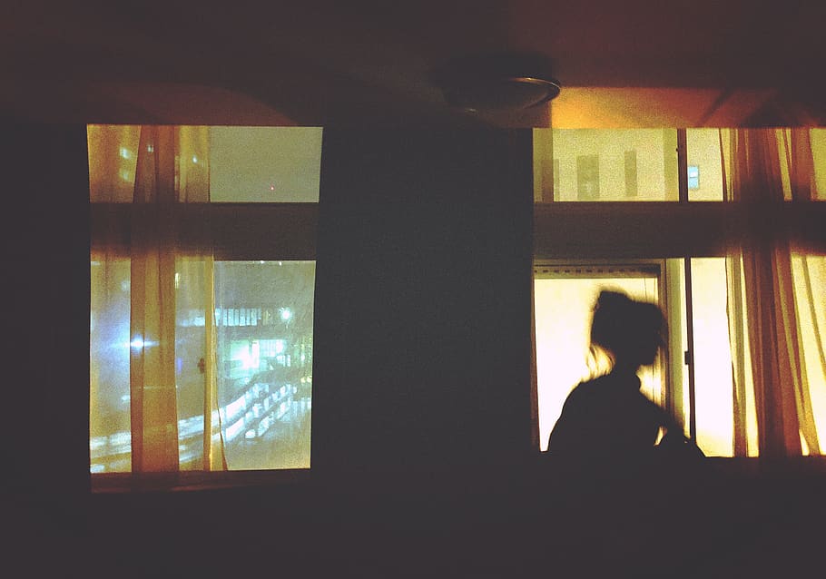 silhouette of woman standing in front of window, curtain, room