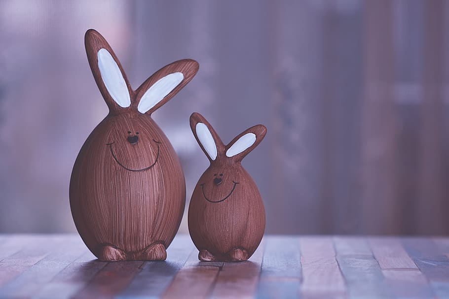 Two Brown and White Rabbit Figurines, blurred background, bright