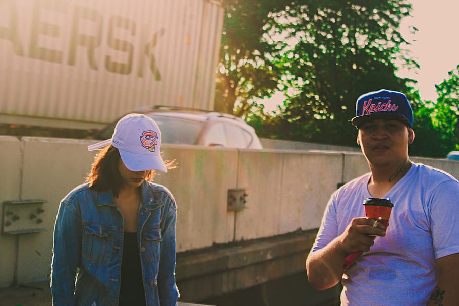 Man Holding Orange Plastic Cup, baseball cap, couple, daylight HD wallpaper