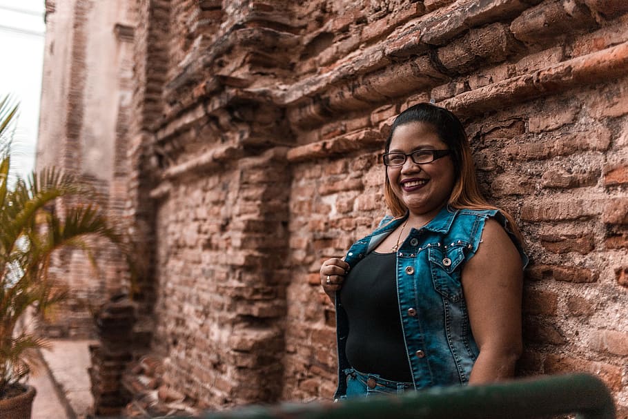 Woman Leaning on Brown Brick Wall, bricks, building, daytime HD wallpaper