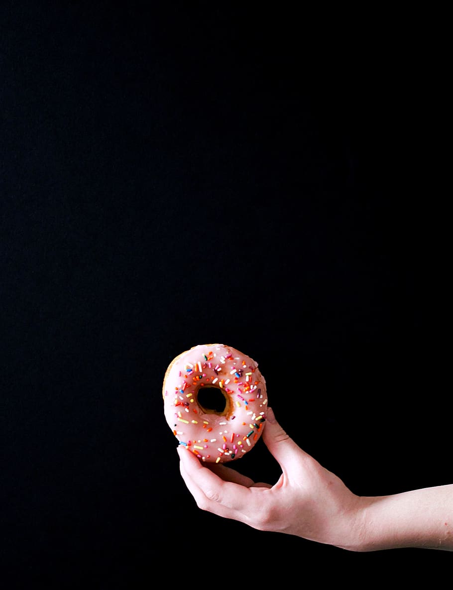 pink doughnut, black background, food and drink, human hand, holding HD wallpaper