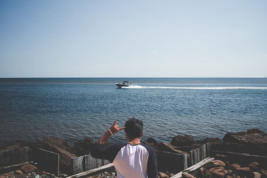 Man Wearing Blue and White T Shirt Next to a Seashore, boat, gesture HD wallpaper