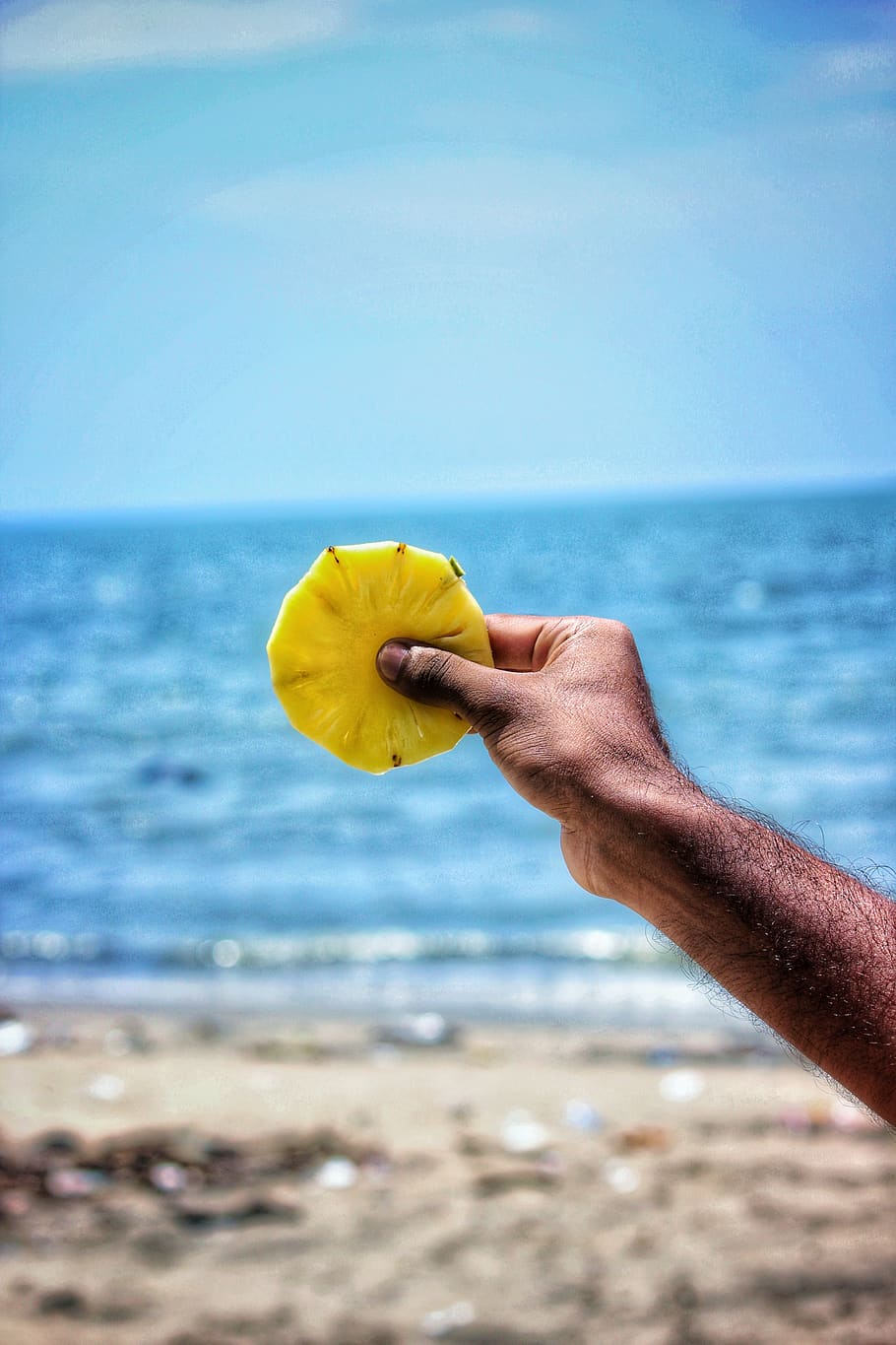 Person Holding Sliced Pineapple , beach, hand, macro, ocean, sand HD wallpaper