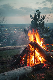 Photo of Bonfire Placed on High Ground in Front of City Under Cloudy Sky HD wallpaper