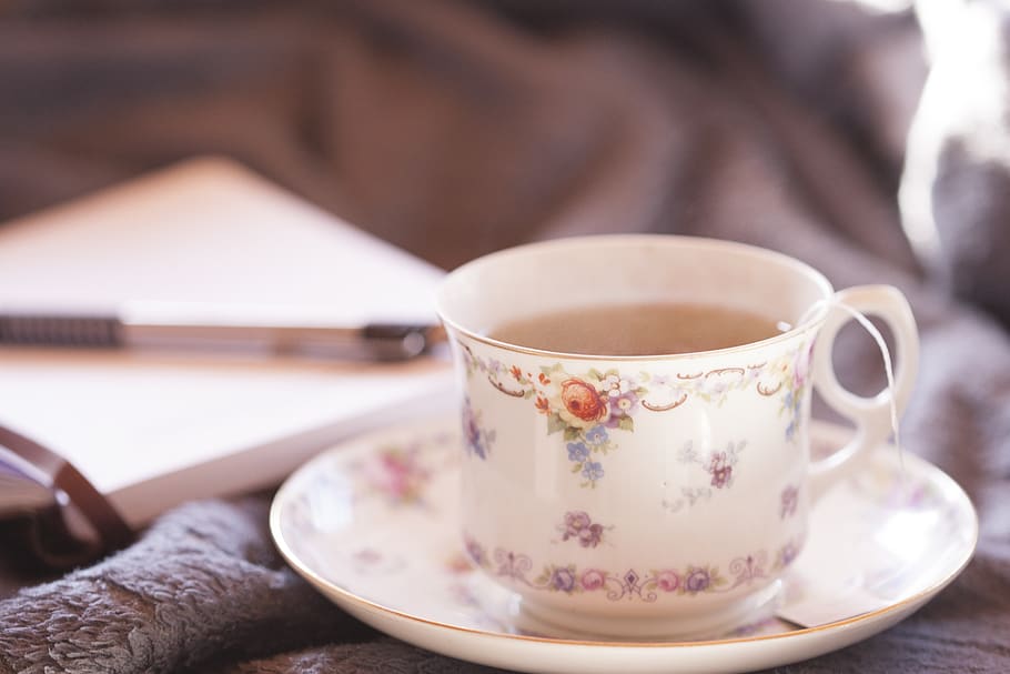 Selective-focus Photography of White and Multicolored Floral Ceramic Teacup on Saucer Filled With Coffee HD wallpaper