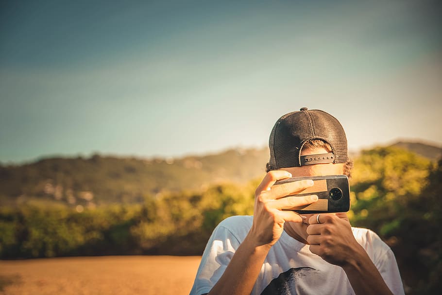 Man Taking Photo, blurred background, camera, camera lens, cap HD wallpaper
