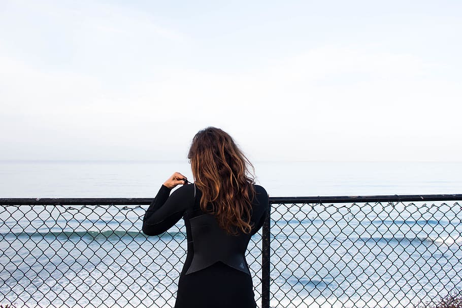 woman leaning on fence facing sea, person, human, people, ocean