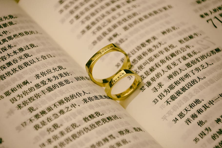 gold-colored rings on book, jewelry, ornament, text, character