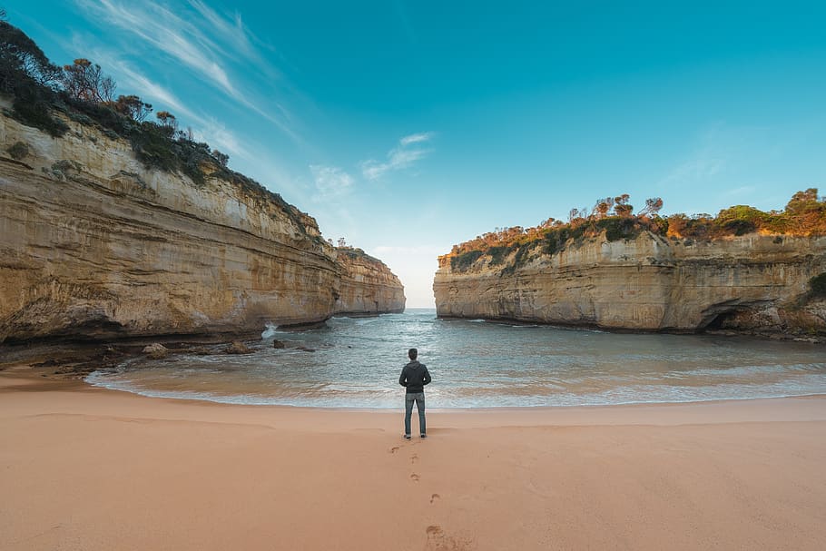 man standing on seashore, water, beach, land, sky, one person HD wallpaper
