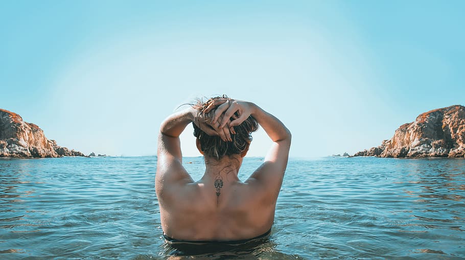 Woman on Holding Her Head While Standing on Body of Water, beach