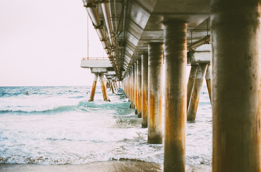 beach, sand, water, waves, shore, splash, pier, structure, poles HD wallpaper
