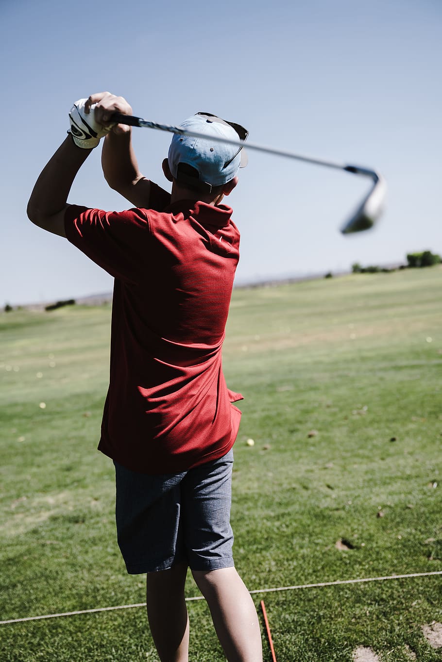 Man Swinging Golf Club Facing Grass Field, adult, athlete, ball