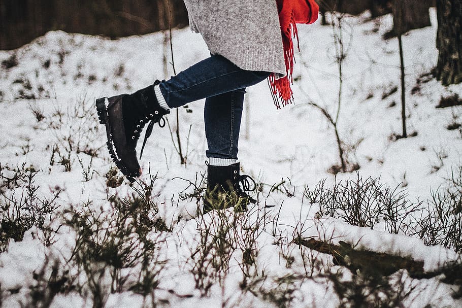 person walking on snow wearing black boots, apparel, clothing