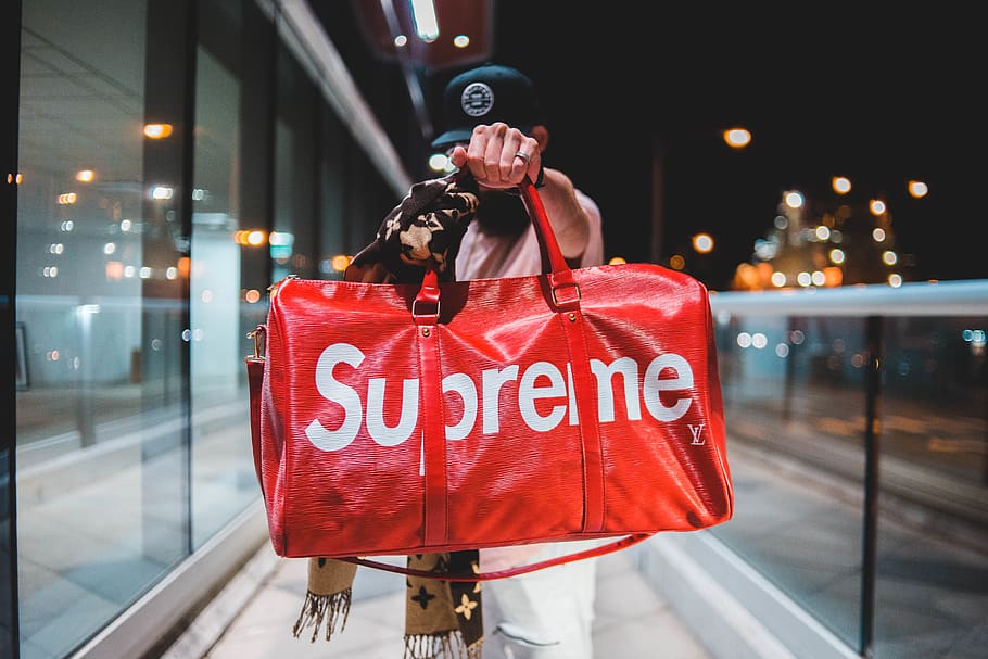 HD wallpaper: person holding red and white Supreme leather duffel bag  outdoor