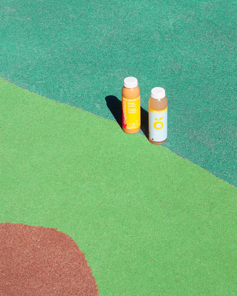 two orange and white labeled bottles, green color, high angle view HD wallpaper